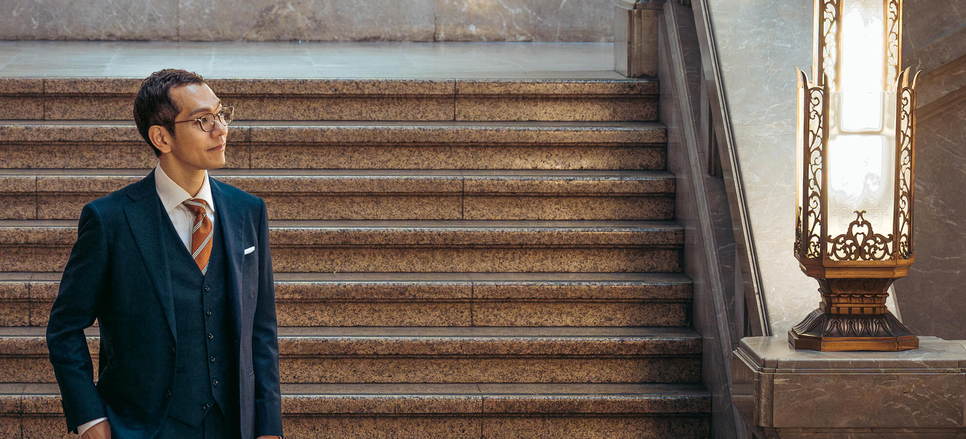 自然の中で静かたたずむ小田真嘉。大地と向き合い、文明進化の思想を深める一場面。